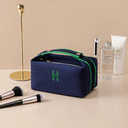 Stylish eprolo portable premium canvas makeup bag in navy blue with green accents, shown beside cosmetic products and makeup brushes, ideal for traveling and organizing beauty essentials.